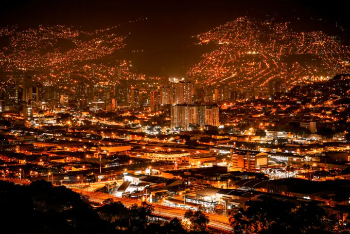 A vibrant aerial view of Medellín's illuminated skyline at night, showcasing the bustling urban landscape. – The Bottom Line on Medellín After Dark