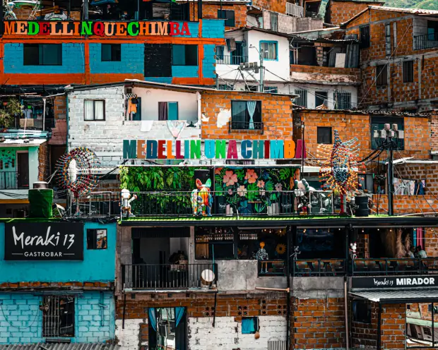 Colourful Comuna 13 hillside houses with the Medellin Que Chimba mural and a rooftop gastrobar – How Much Does a Night Out in Medellin Cost?