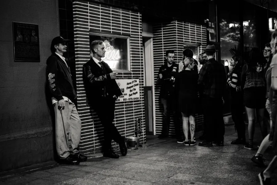 People waiting outside a dark club door at night – getting past the door at a selective techno club