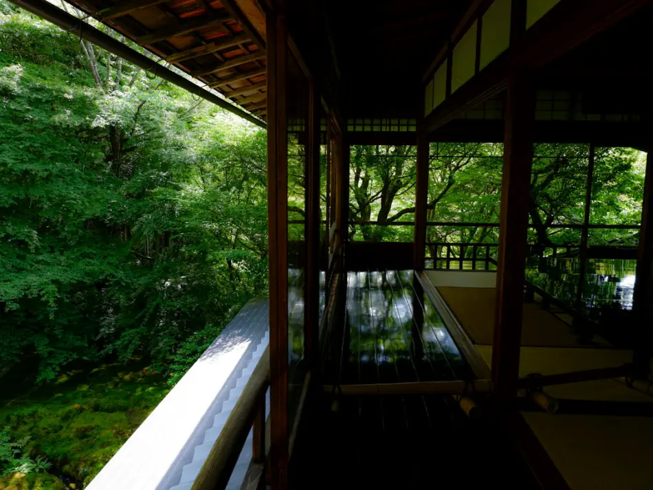 Wooden ryokan veranda opening onto a green garden and bath wing – what an onsen is section, Japan