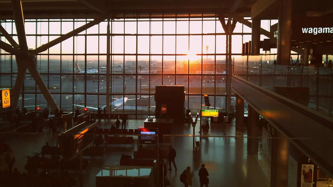 Sunrise through the glass wall of a busy airport terminal – when an open-jaw ticket saves money