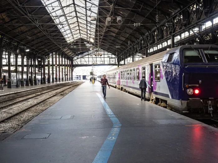 Interior view of a Paris train station showing a train and passengers on the platform. – The Best Night Train Routes in Europe Right Now (2026)