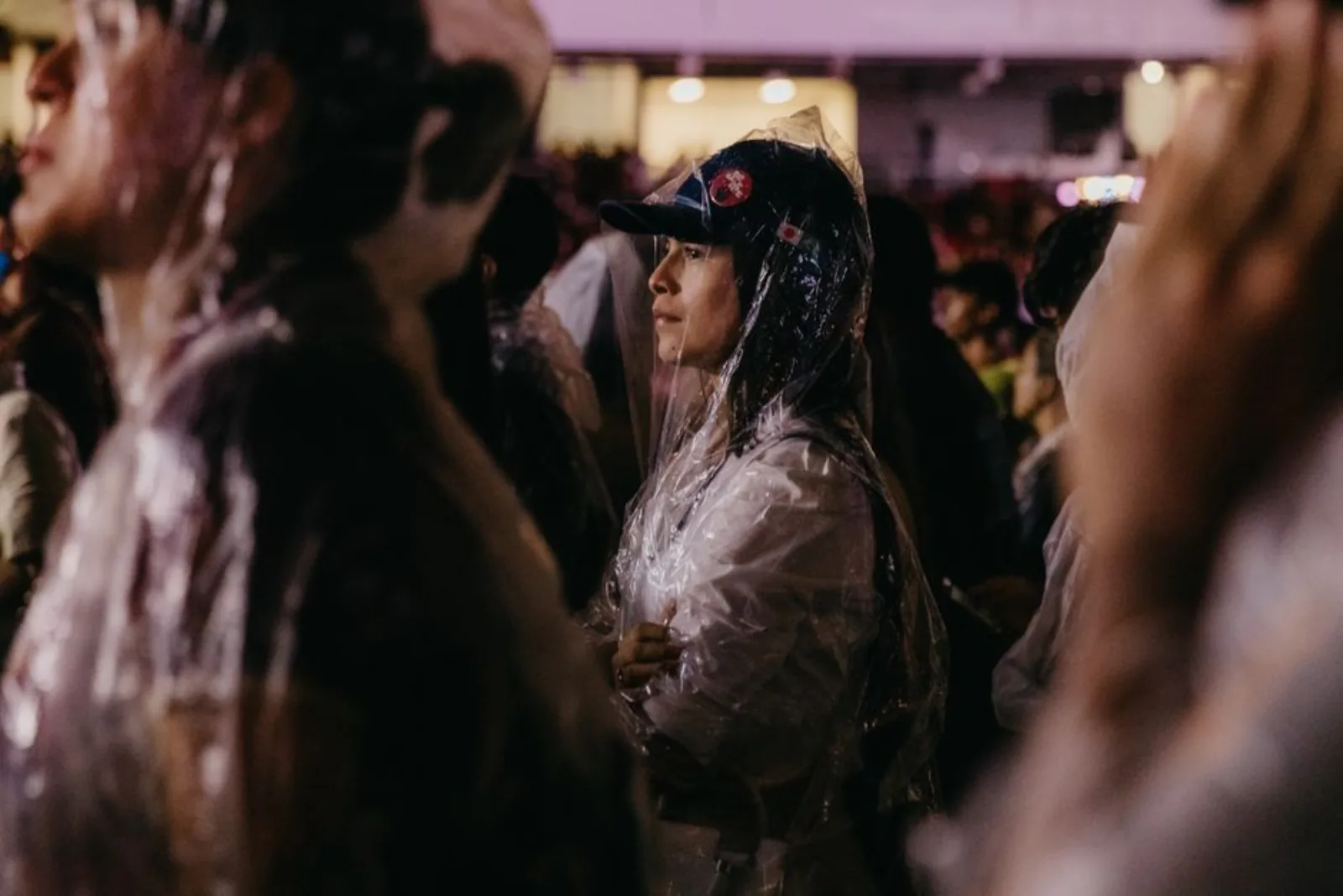 People in rain ponchos enjoy The Send Festival in Pará, Brazil, showcasing resilience and community spirit. – Does Travel Insurance Cover Festival Cancellation?